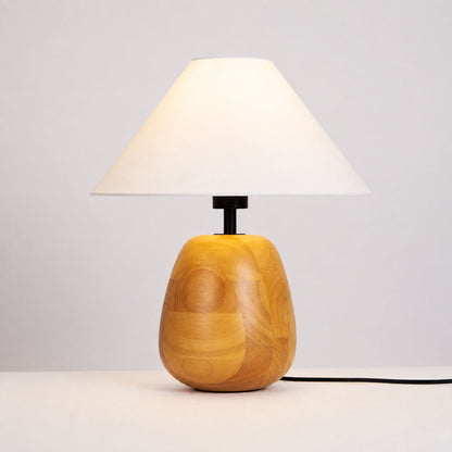Nord wood table lamp illuminated warm inviting glow white fabric shade natural wood cozy white background