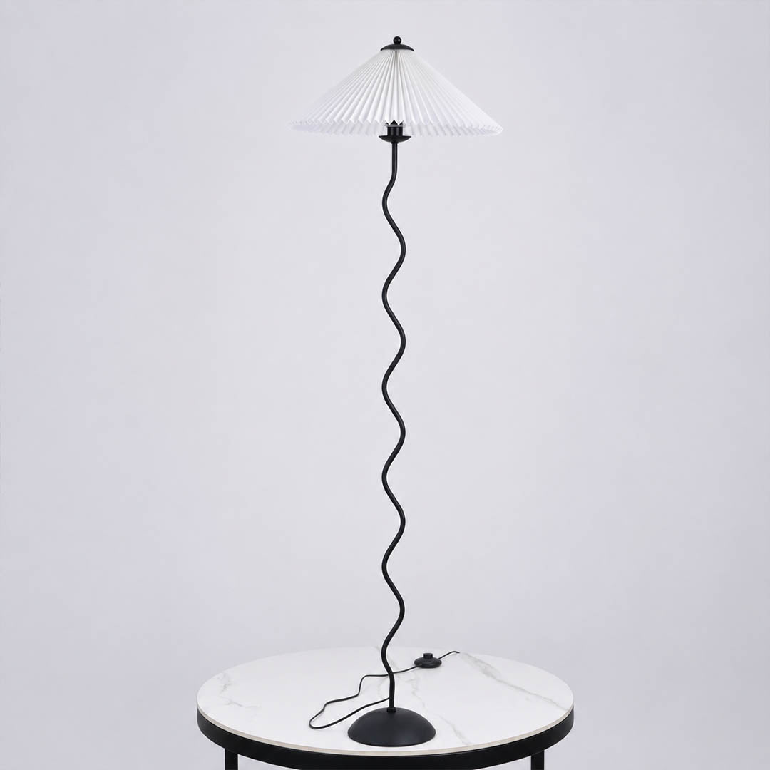 Onda floor lamp beige modern reading corner armchair sculptural squiggle wavy black metal base fabric drum shade postmodern Memphis inspired warm cozy ambient lifestyle interior