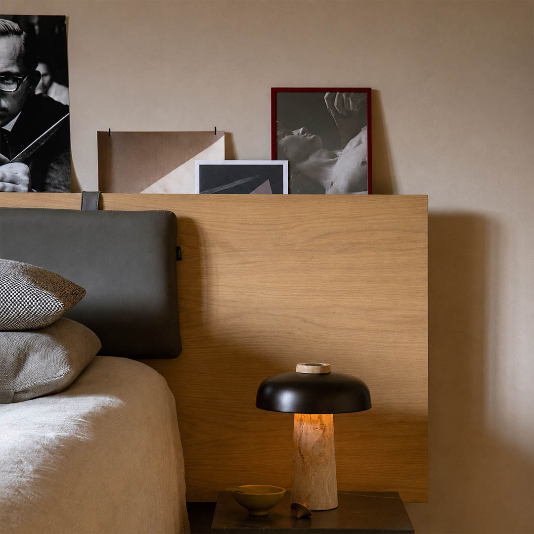 Onda small travertine dome table lamp modern industrial bedside nightstand primary master bedroom minimalist matte black walnut wood warm glow lifestyle interior
