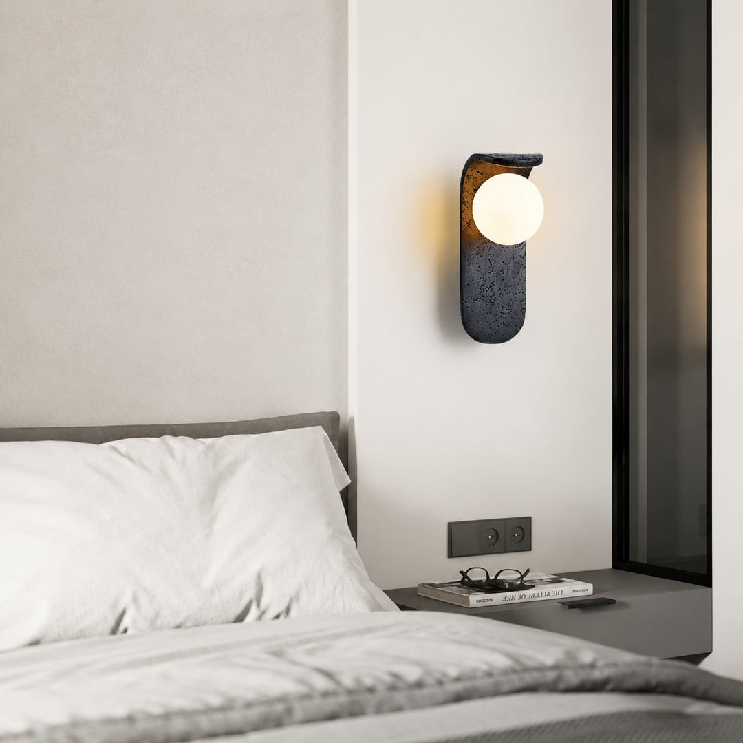 Notte travertine wall sconce bedroom bedside warm glow black travertine stone orb minimalist American home lifestyle interior styled