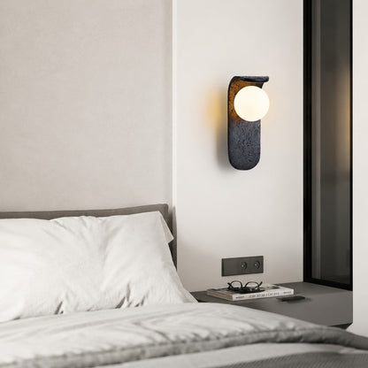 Notte travertine wall sconce bedroom bedside warm glow black travertine stone orb minimalist American home lifestyle interior styled