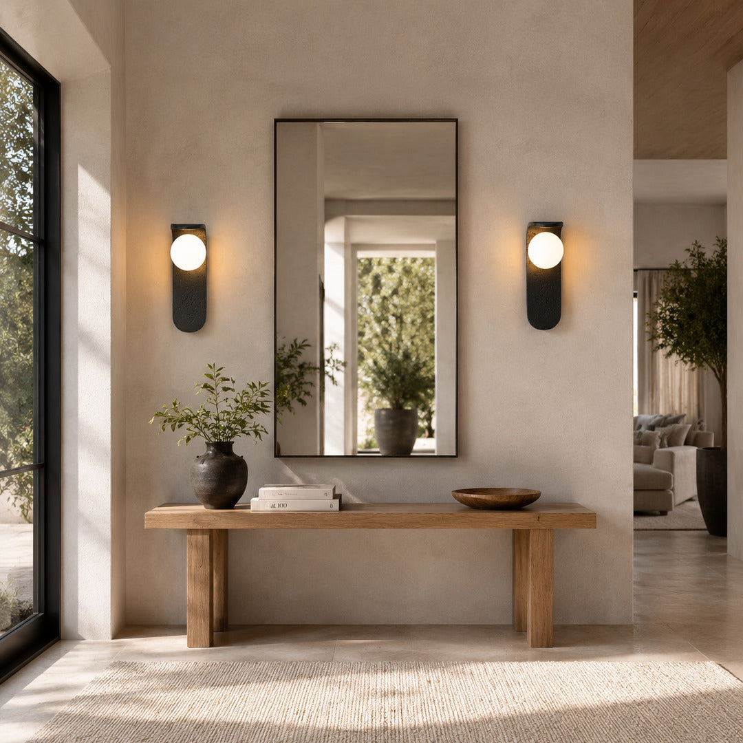 Notte travertine wall sconce entryway foyer warm glow black travertine stone orb American home lifestyle interior styled
