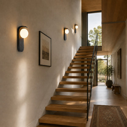 Notte travertine wall sconce staircase stairwell warm glow black travertine stone orb American home lifestyle interior styled