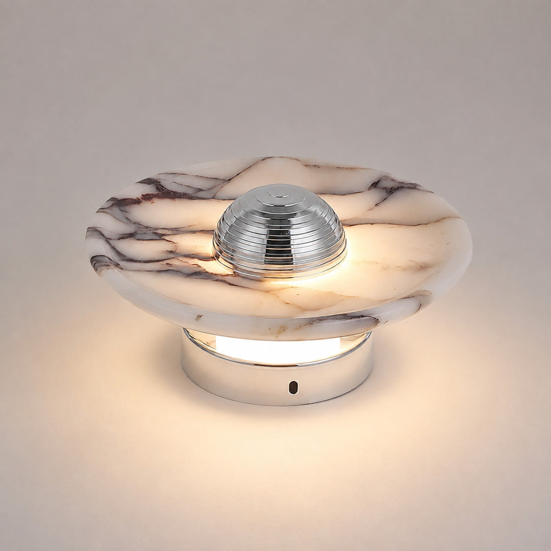 Close-up of the natural marble disc on the Orbe wall sconce showing its unique veining, different on every piece