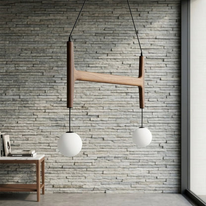 Orbit walnut orb chandelier above dining table warm frosted globe glow organic modern interior
