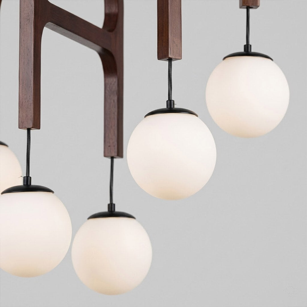Orbit walnut orb chandelier above dining table warm frosted globe glow organic modern interior