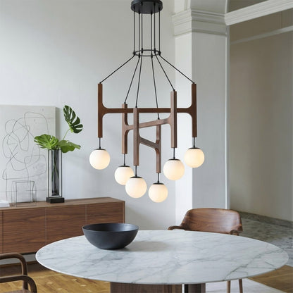 Orbit walnut orb chandelier above dining table warm frosted globe glow organic modern interior