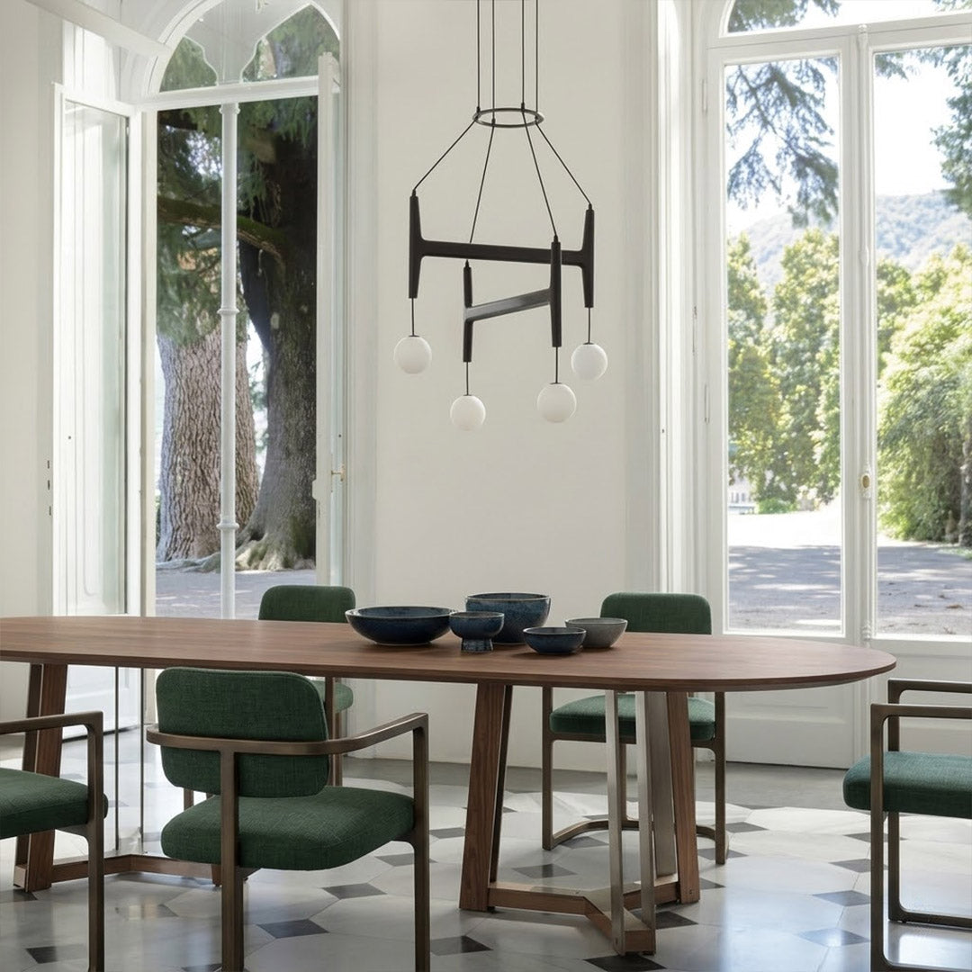 Orbit walnut orb chandelier above dining table warm frosted globe glow organic modern interior