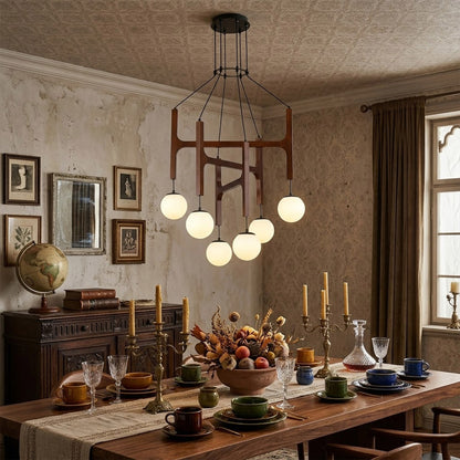 Orbit walnut orb chandelier above dining table warm frosted globe glow organic modern interior