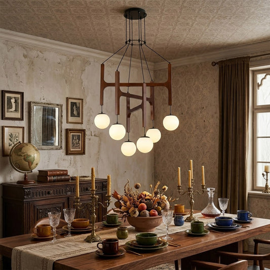 Orbit walnut orb chandelier above dining table warm frosted globe glow organic modern interior