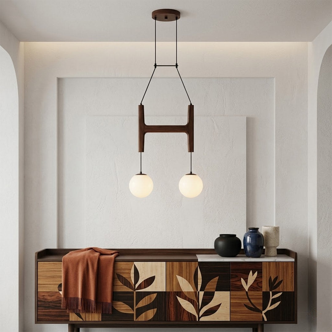 Orbit walnut orb chandelier above dining table warm frosted globe glow organic modern interior