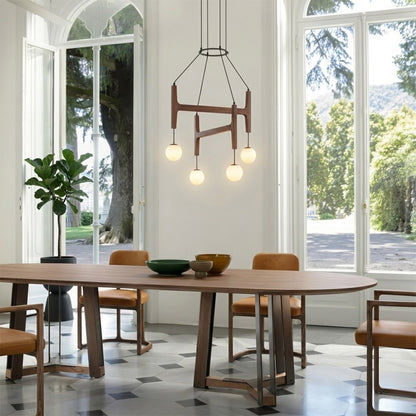 Orbit walnut orb chandelier above dining table warm frosted globe glow organic modern interior