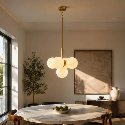 Orbita alabaster globe pendant light dining room above table cluster natural stone brass warm glow American home lifestyle interior styled
