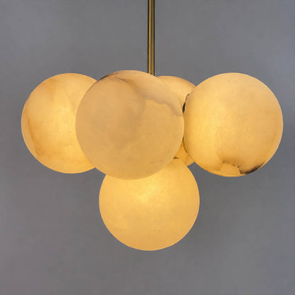 Orbita alabaster globe pendant light illuminated glowing veining warm soft radiance translucent stone sphere detail close up quiet luxury