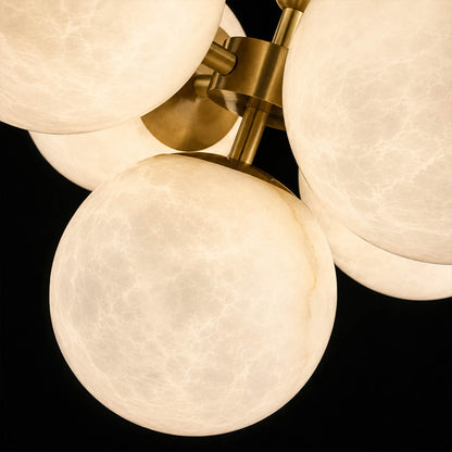Orbita alabaster globe pendant light illuminated glowing veining warm soft radiance translucent stone sphere detail close up quiet luxury