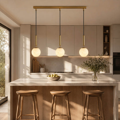 Orbita alabaster globe pendant light kitchen island above counter natural stone brass warm glow mid century American home lifestyle interior styled