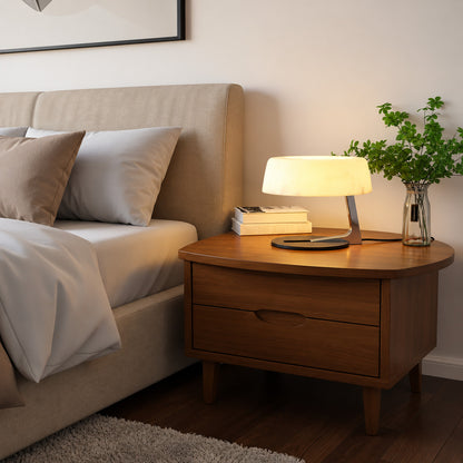 Orbita alabaster table lamp casting a soft glow on a bedside table