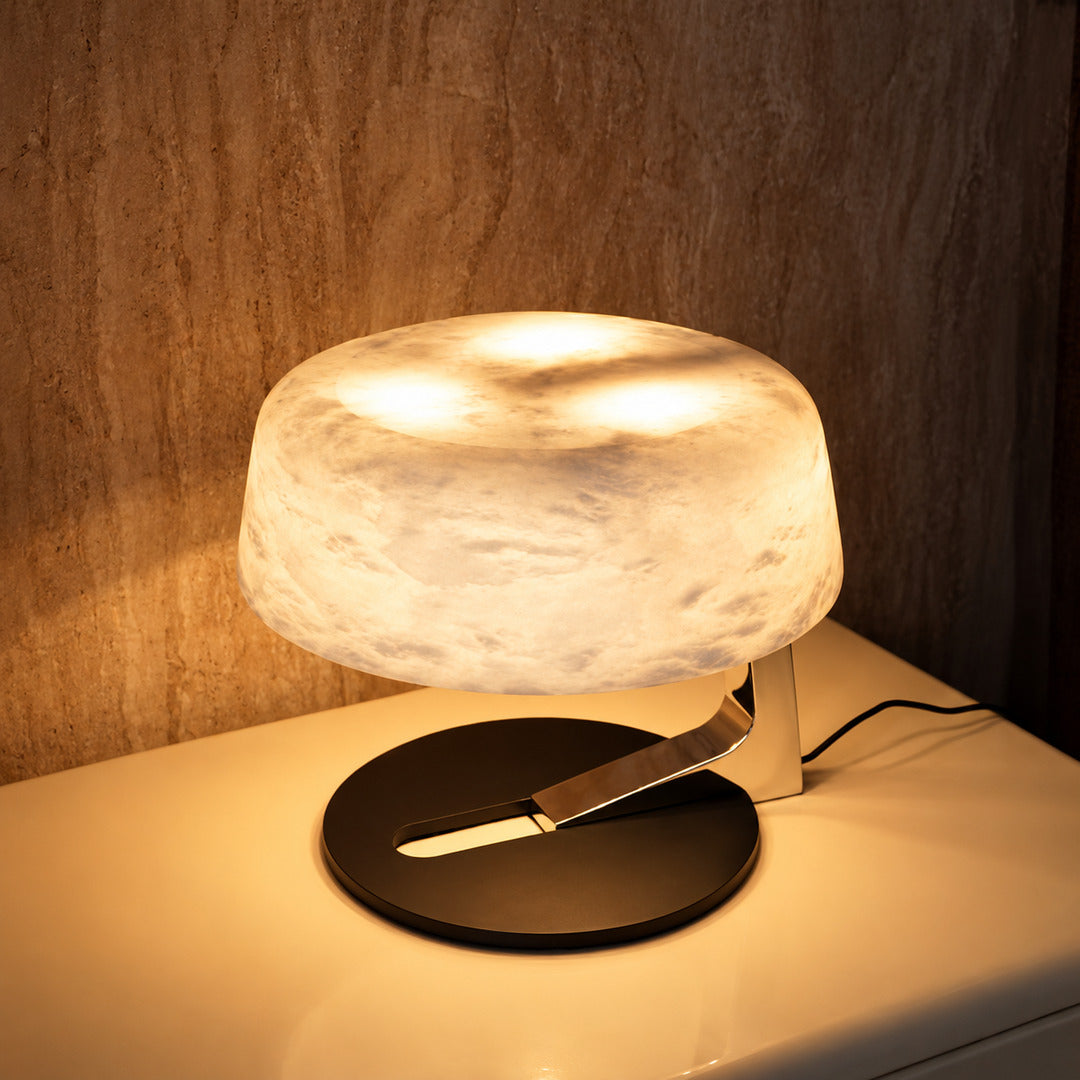 Pair of Orbita alabaster table lamps on nightstands flanking a bed