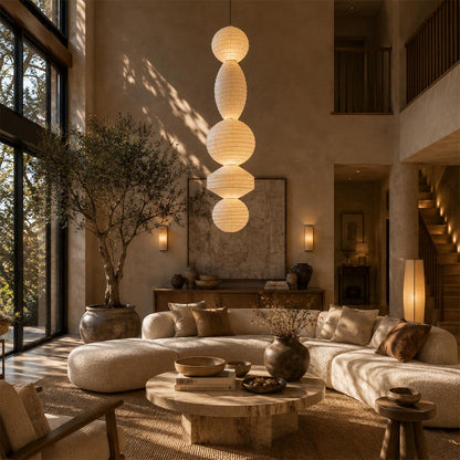 Dramatic tall Ori Lantern Series Pendant Light hanging in a luxurious high-ceiling Wabi-Sabi living room by Stuber Lighting.