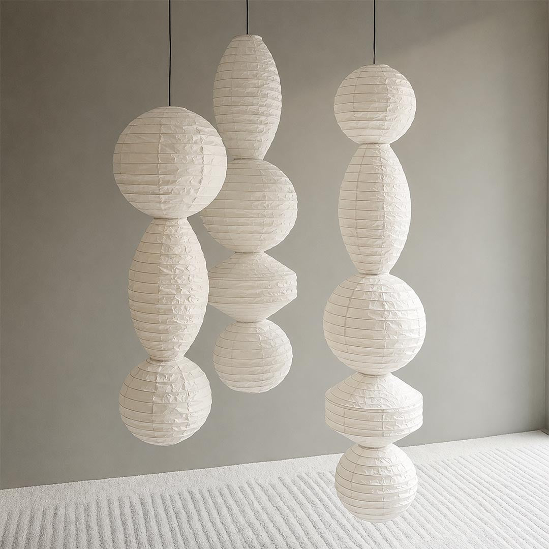 Three different styles of unlit Washi paper shades from the Ori Lantern Series hanging together against a grey wall by Stuber Lighting.