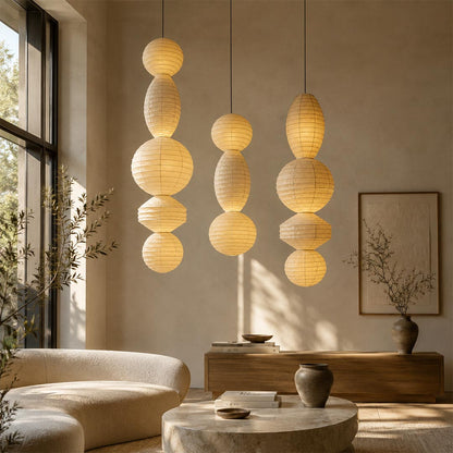 Organic modern living room decorated with a pair of layered Ori Lantern Series Paper Lamps under dramatic sunlight by Stuber Lighting.
