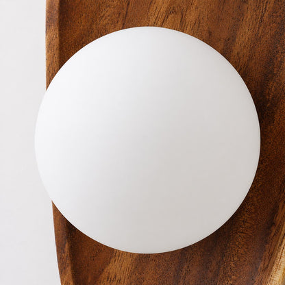 Ovi wood wall lamp illuminated warm soft ambient glow frosted milky white glass globe evening cozy wabi sabi mood detail close up