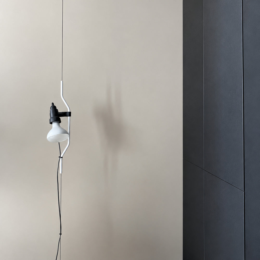 White Parentheses lamp on a white wall in a minimalist modern interior