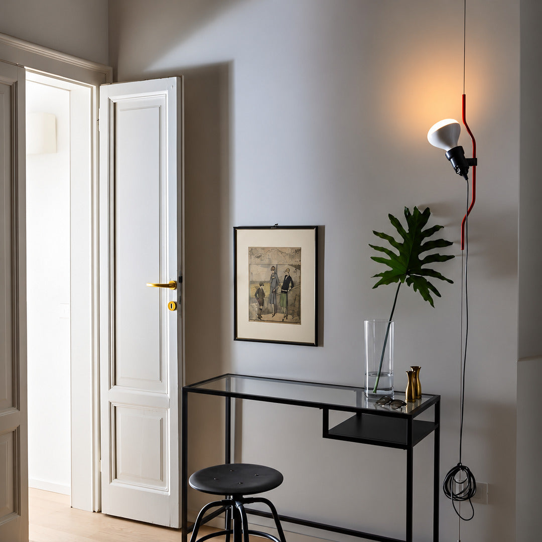 White Parentheses floor to ceiling lamp beside an entryway bench as a sleek accent light