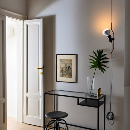 White Parentheses floor to ceiling lamp beside an entryway bench as a sleek accent light