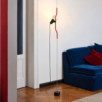Black Parentheses lamp with its spotlight lowered beside a sofa arm for evening reading