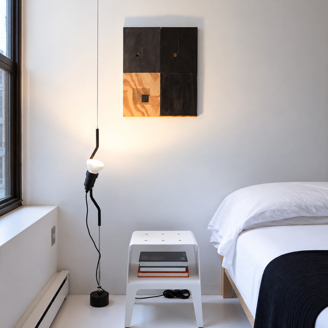 Black Parentheses cable lamp against a brick wall in an industrial loft
