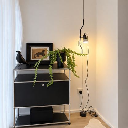 Black Parentheses cable lamp against a brick wall in an industrial loft