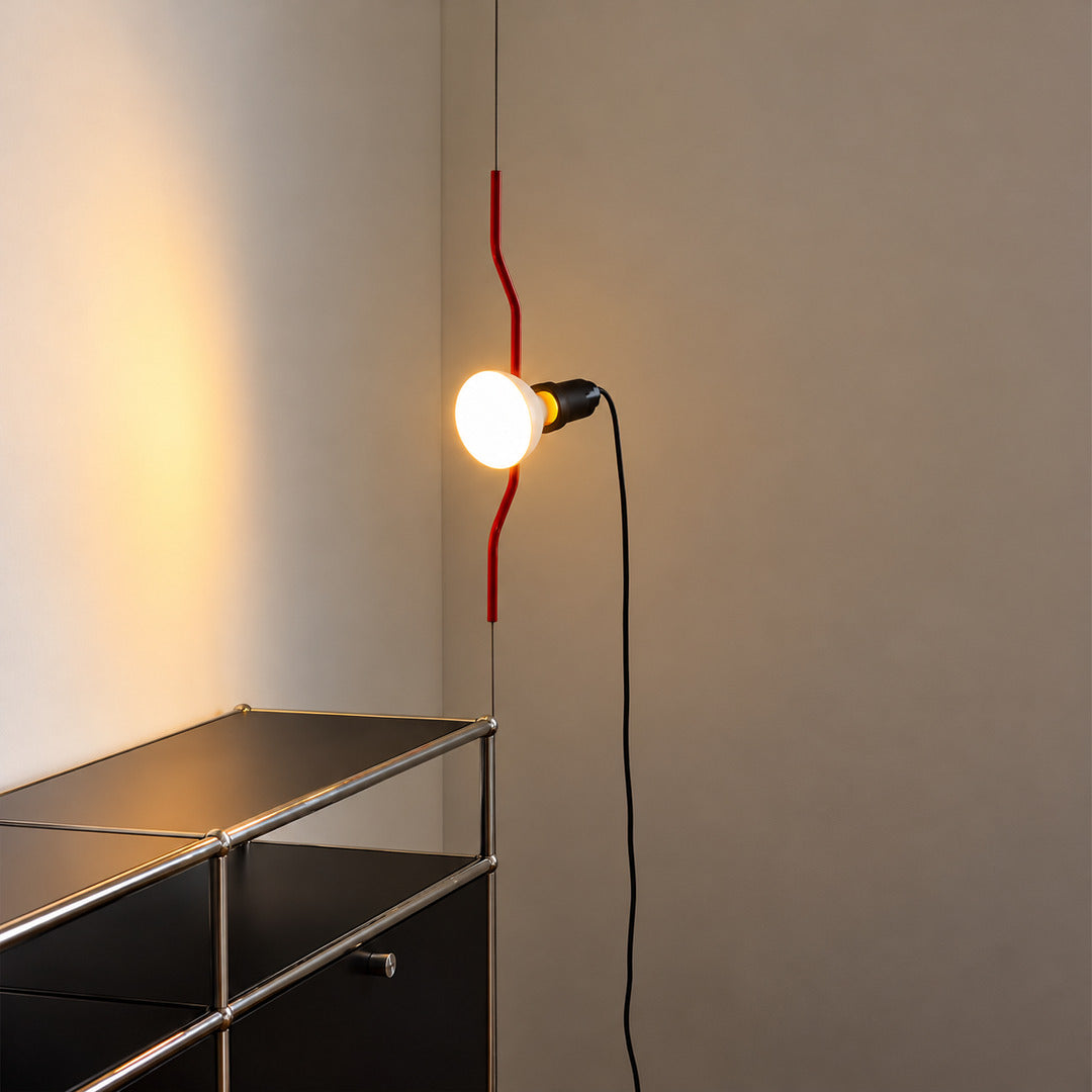 Parentheses spotlight lamp lighting a drafting table in a creative studio