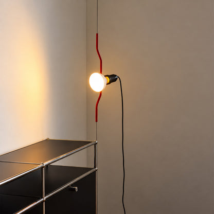 Parentheses spotlight lamp lighting a drafting table in a creative studio