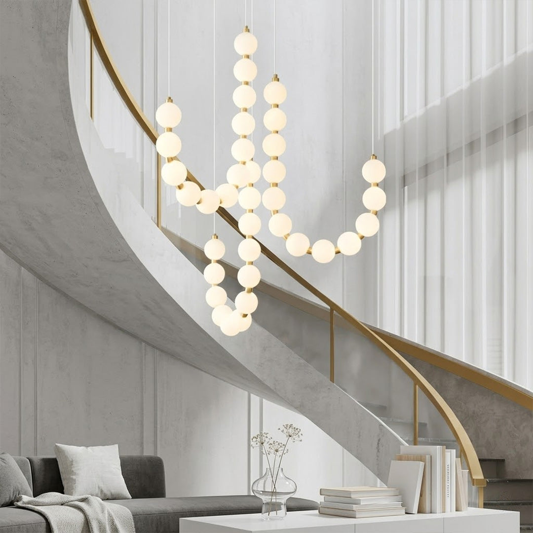 Pearla beaded chandelier above open staircase stairwell two-floor view warm glow