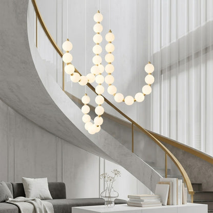 Pearla beaded chandelier above open staircase stairwell two-floor view warm glow