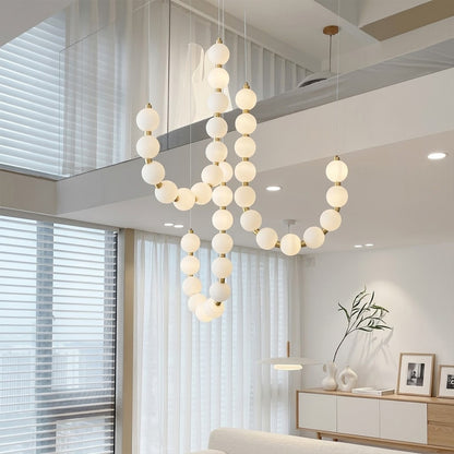 Pearla beaded chandelier hanging in two-story foyer cascading pearl strands elegant entryway