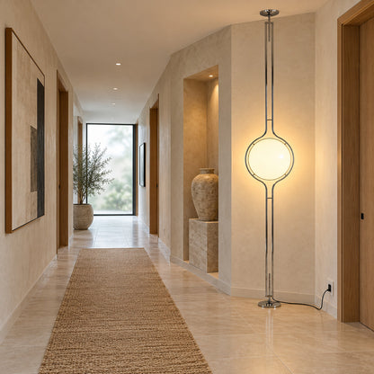 Pendolo silver globe pole lamp glowing at the end of a long hallway