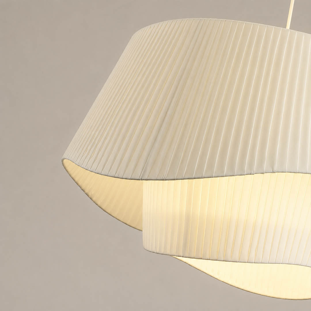Plisse pleated pendant light warm diffused soft glow fabric shade cozy inviting detail close up