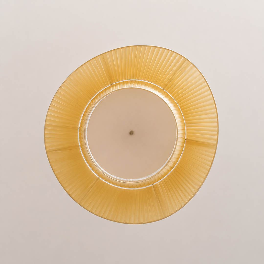 Plisse pleated pendant light warm diffused soft glow fabric shade cozy inviting detail close up