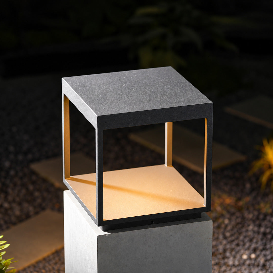 Quadro outdoor post light mounted on a fence post casting crossing light patterns