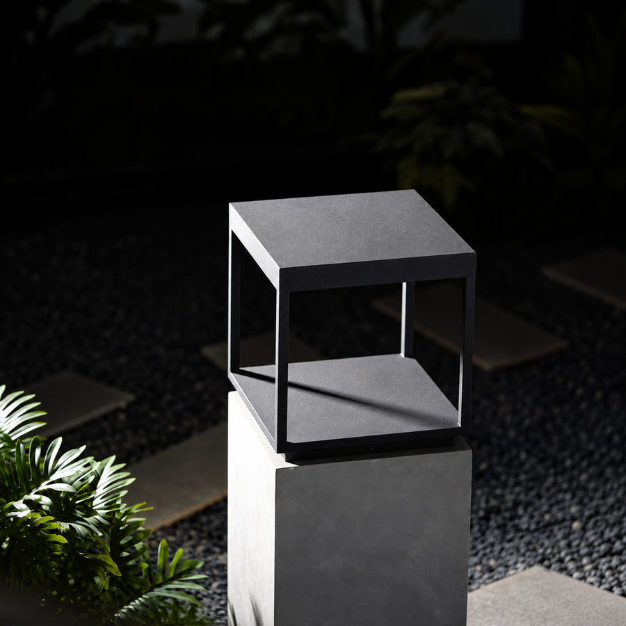 Quadro outdoor post light mounted on a fence post casting crossing light patterns
