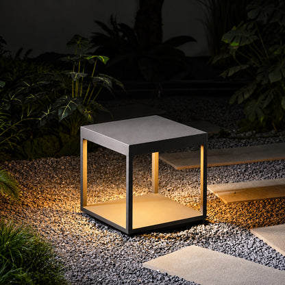 Quadro outdoor post lights lining a garden bed with a warm modern glow at dusk