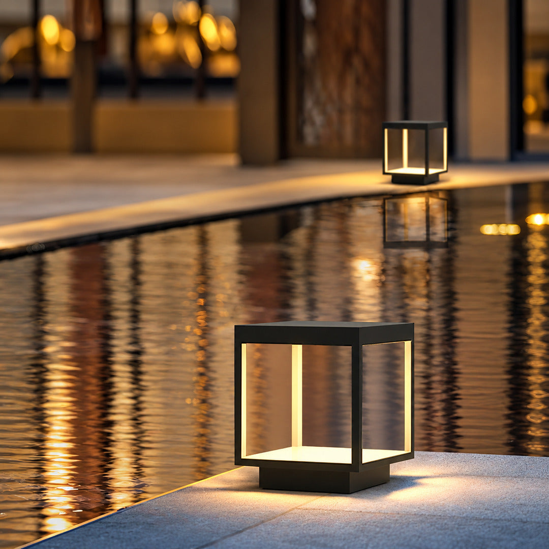 Quadro outdoor post lights lining a pool surround with a warm modern glow