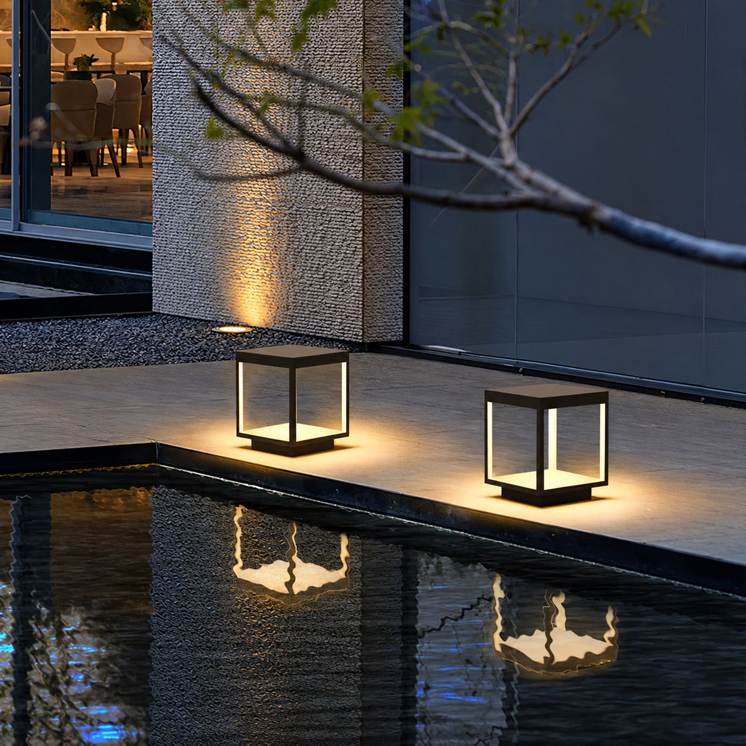 Quadro outdoor post lights lining a pool surround with a warm modern glow