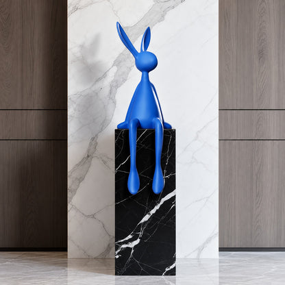 Rabbit resin sculpture displayed on a sideboard or display cabinet as an art accent