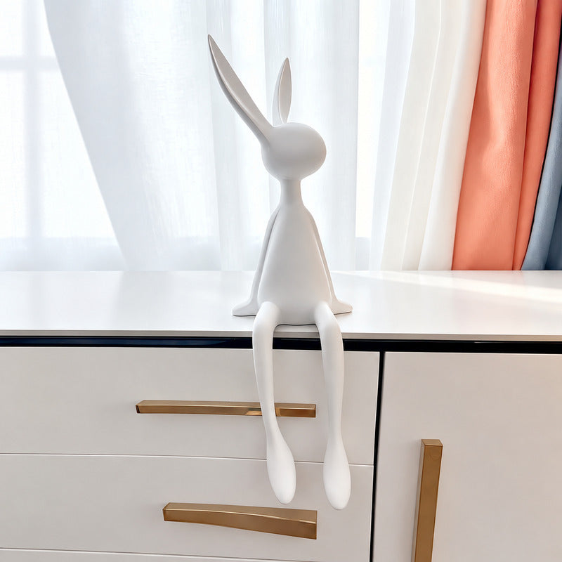 Rabbit resin sculpture on a media console adding a playful modern touch