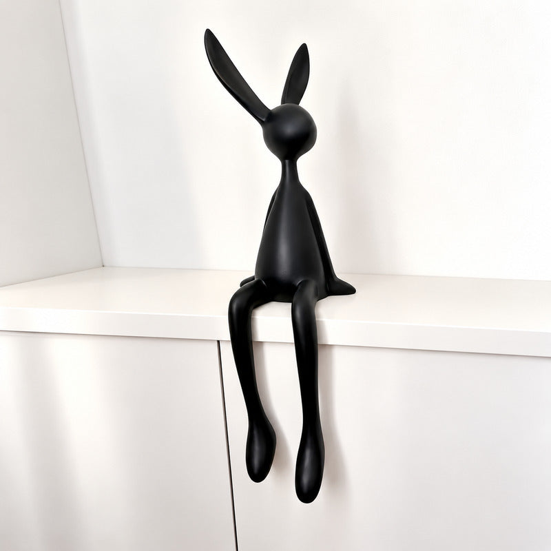 Medium 27.6-inch black rabbit resin sculpture on a media console
