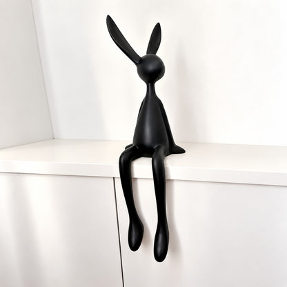 Medium 27.6-inch black rabbit resin sculpture on a media console