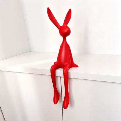 Small 19.7-inch red rabbit resin sculpture adding a pop of color to a shelf